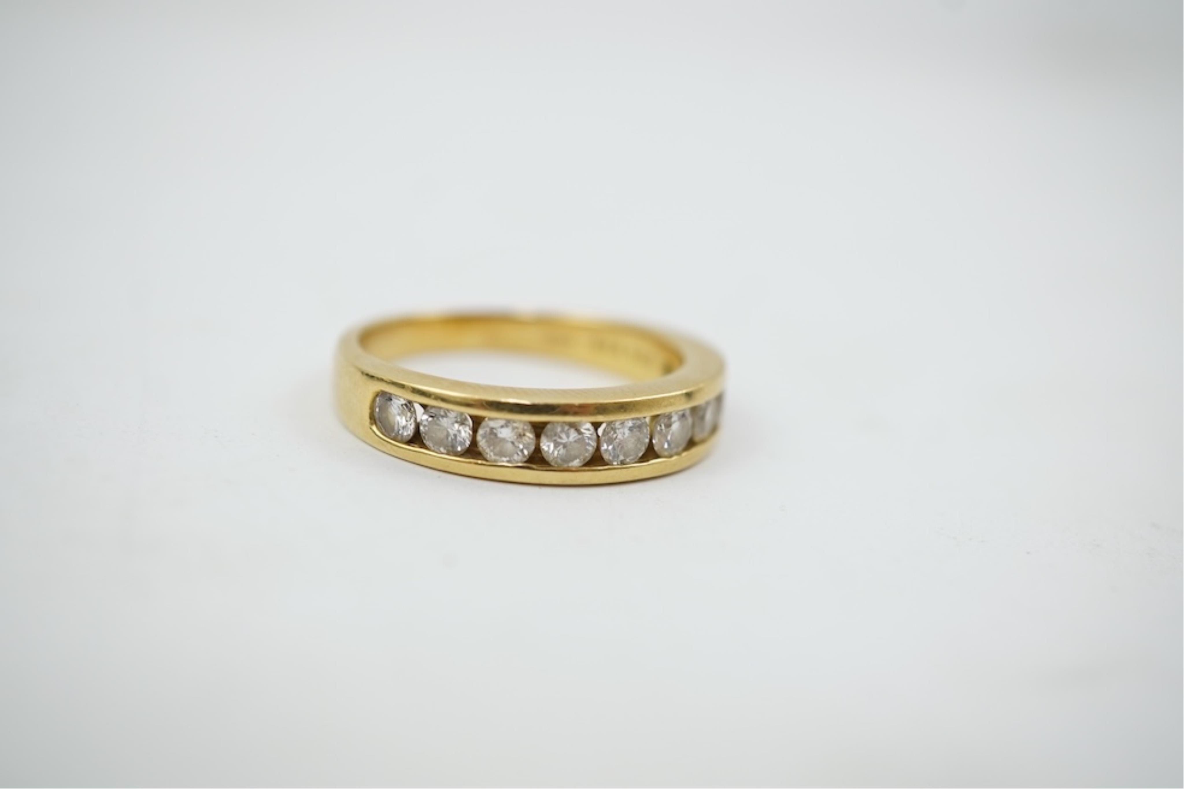 A modern 18ct gold and channel set graduated ten stone diamond set half eternity ring, size Q, gross weight 5.4 grams.